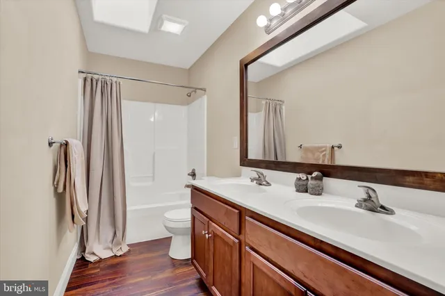 a bathroom with a sink a toilet and a large mirror