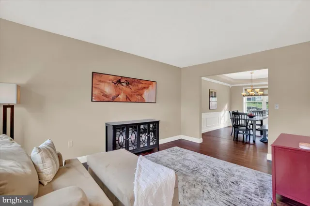a bedroom with a bed and dresser with wooden floor