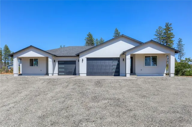 a front view of a house with a garden and yard