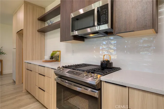 a kitchen with kitchen island granite countertop a sink a counter top space appliances and cabinets