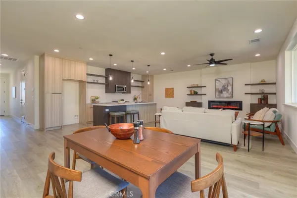 a kitchen with stainless steel appliances a sink a stove a refrigerator cabinets and wooden floor