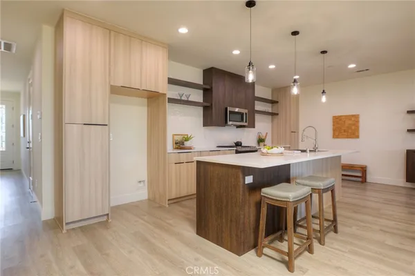 a kitchen with a sink cabinets and wooden floor