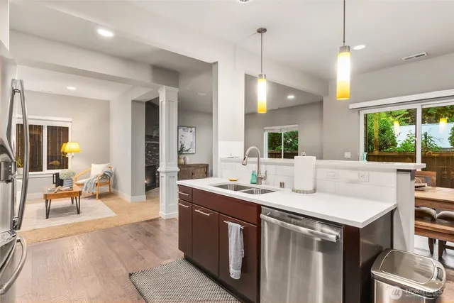 a kitchen with a sink a counter top space and living room view