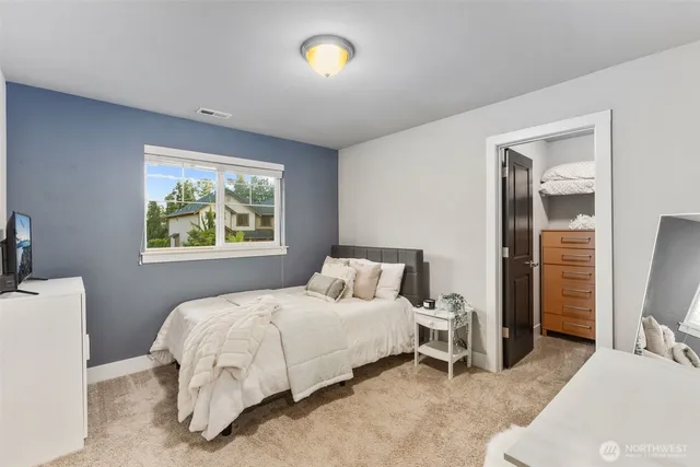 a bedroom with a bed and a flat screen tv
