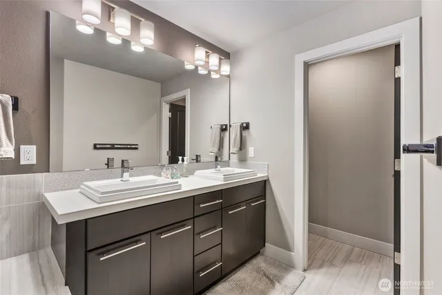 a bathroom with a double vanity sink and a mirror