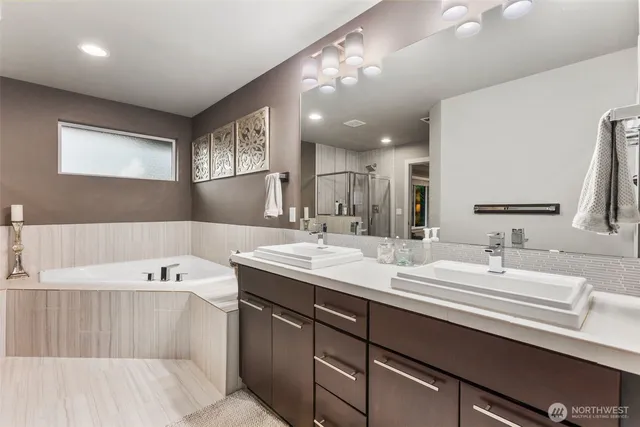 a spacious bathroom with a sink a large mirror and bathtub