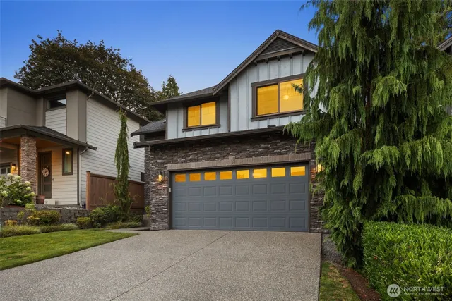 a view of brick house with a small yard and a large parking space