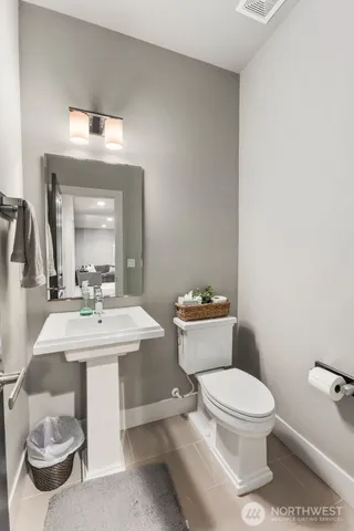 a bathroom with a toilet a sink and a mirror