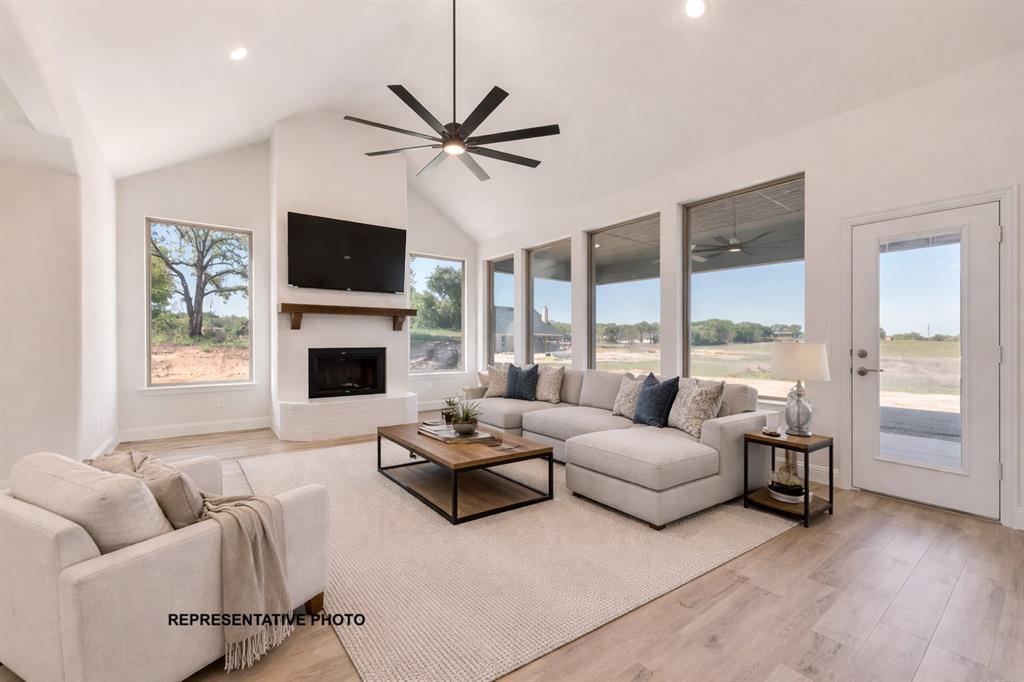 1036 Monaco Court Springtown, TX 76082 - Photo 6 of 12 a living room with furniture a flat screen tv and a large window