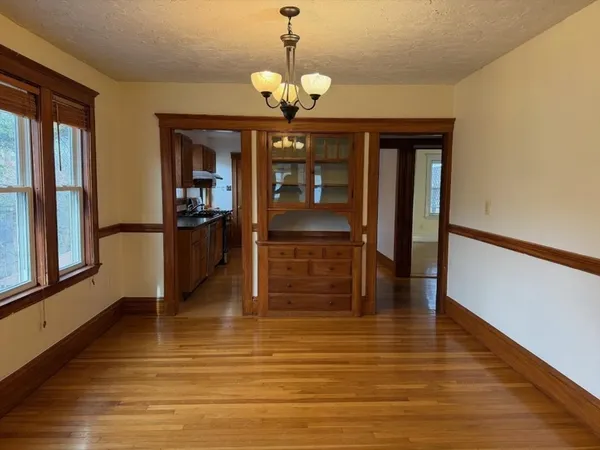 a view of a room with wooden floor staircase and a kitchen
