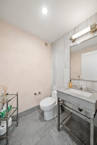 a bathroom with a sink toilet and mirror