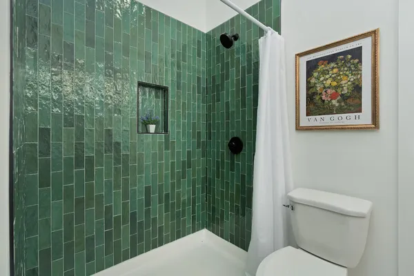 a bathroom with a toilet and a shower