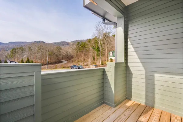 a view of a balcony with wooden floor and fence