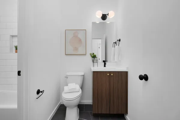 a bathroom with a toilet a sink and mirror