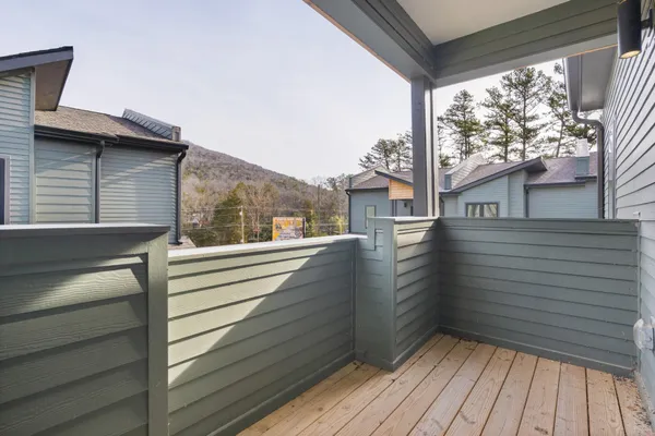 a view of a balcony with wooden floor and fence