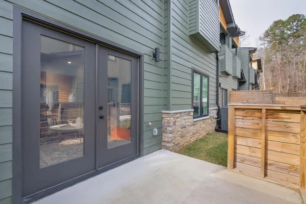 a view of a patio with table and chairs and floor to ceiling window
