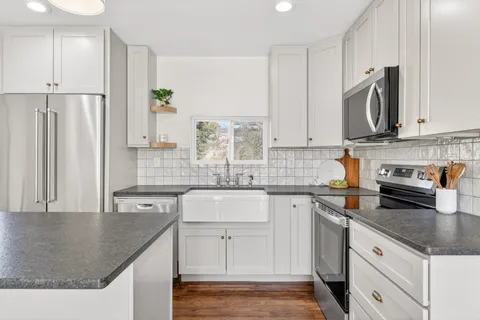 a kitchen with stainless steel appliances granite countertop a sink stove and refrigerator