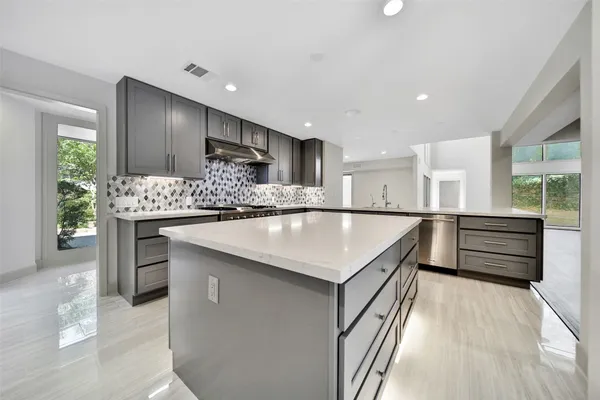 a kitchen with kitchen island a large counter top appliances and cabinets