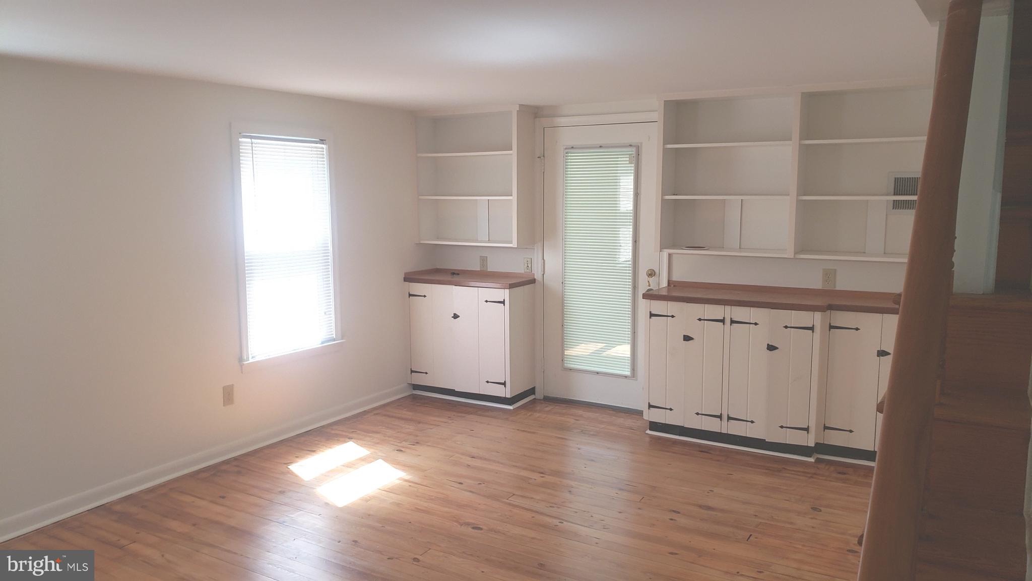 625 Southwood Road Hockessin, DE 19707 - Photo 3 of 16 an empty room with wooden floor and cabinet