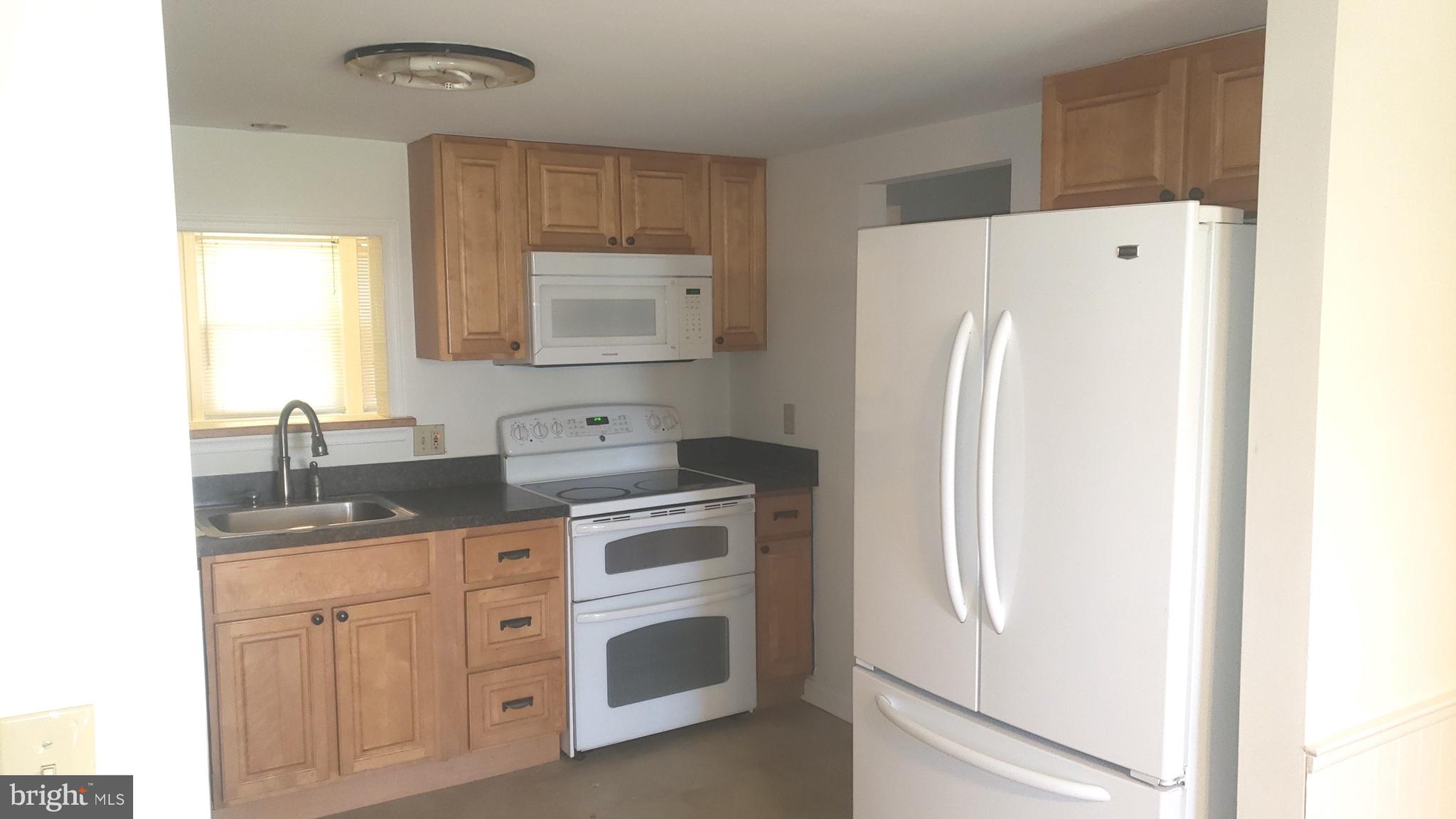 625 Southwood Road Hockessin, DE 19707 - Photo 7 of 16 a kitchen with stainless steel appliances a refrigerator sink and cabinets