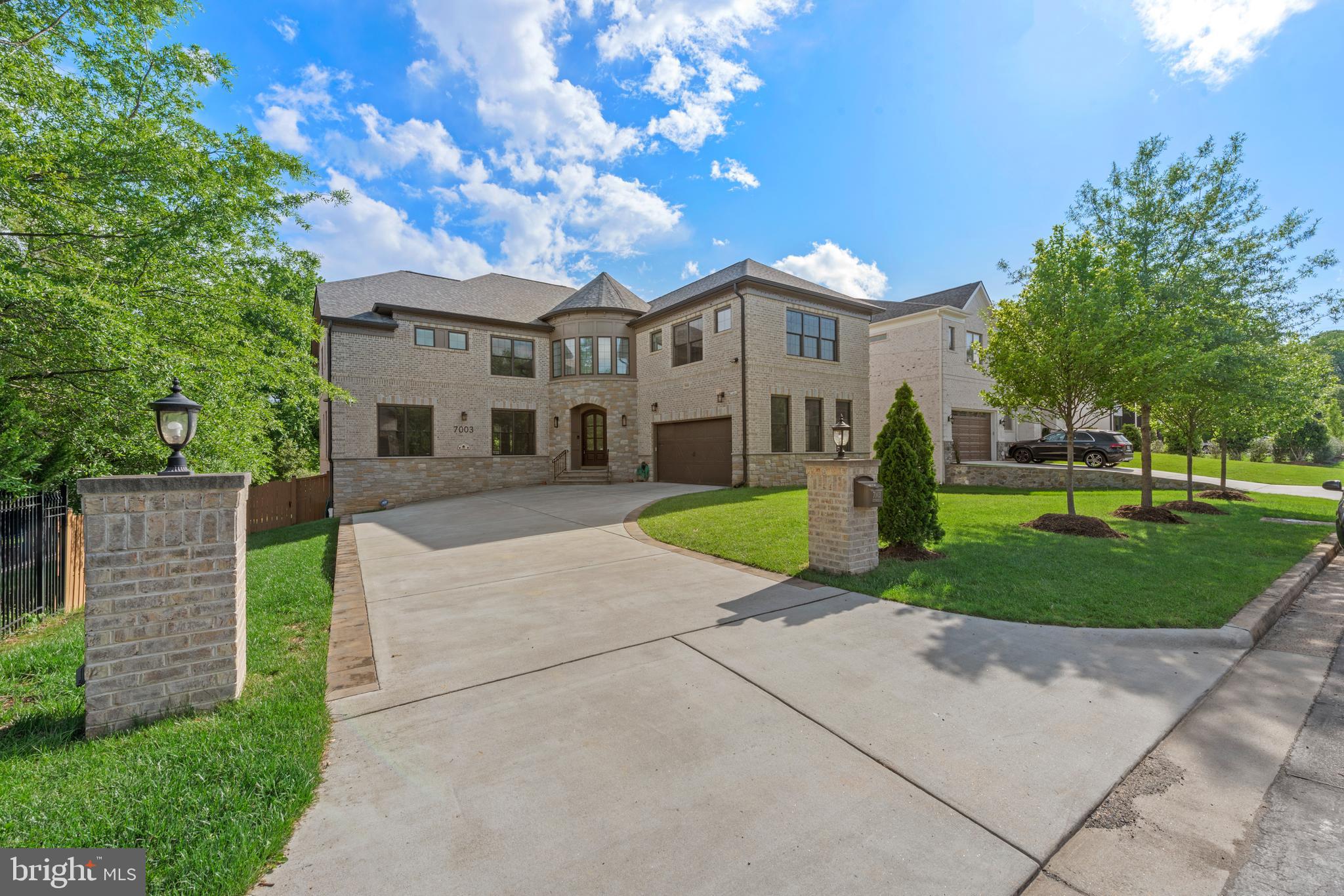 a front view of a house with a yard and trees