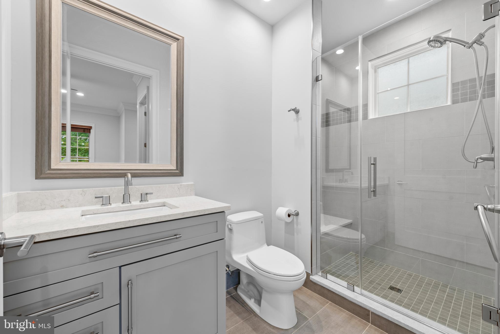 7003 Churchill Road McLean, VA 22101 - Photo 14 of 76 a bathroom with a shower sink vanity mirror and toilet