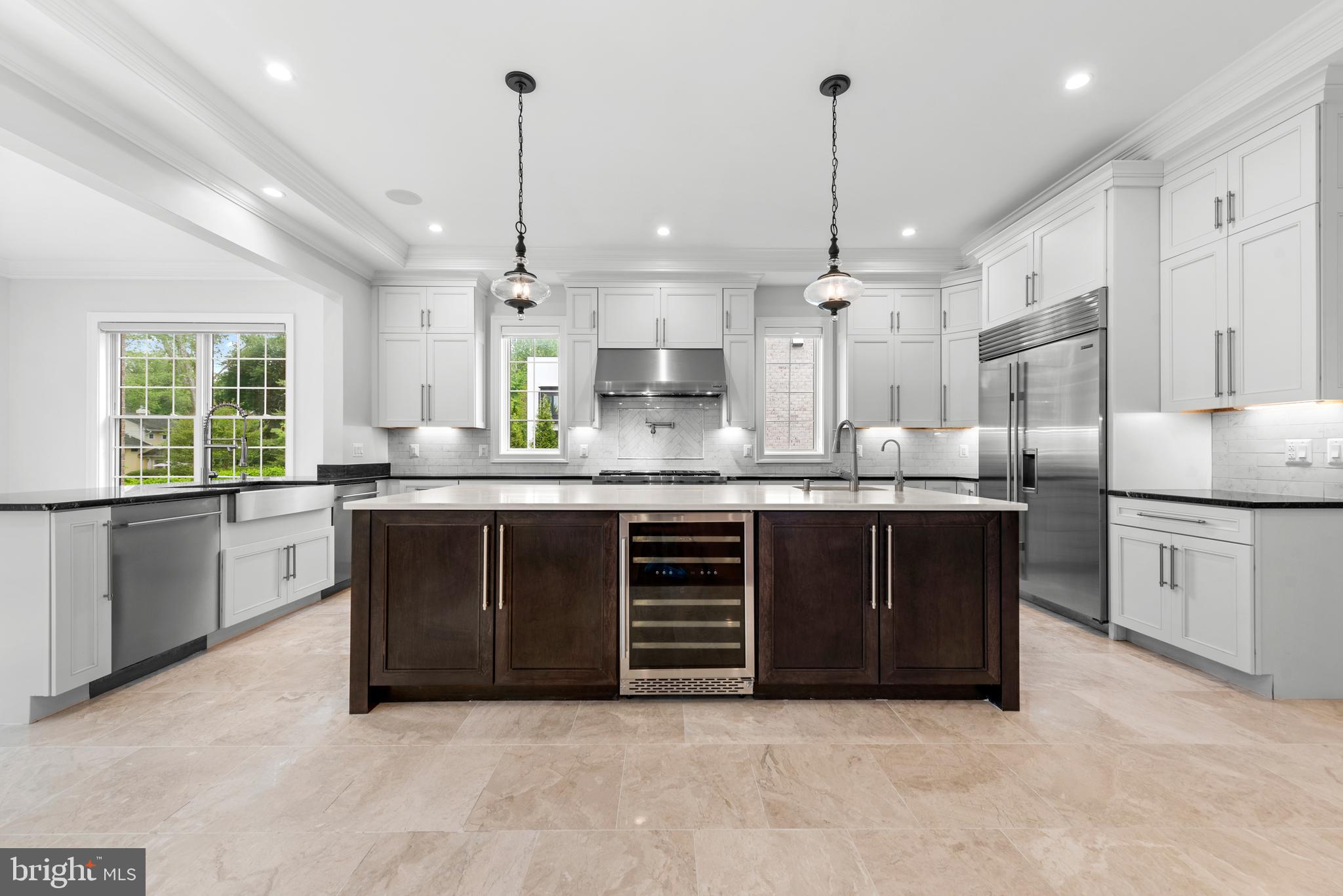 7003 Churchill Road McLean, VA 22101 - Photo 19 of 76 a kitchen with kitchen island granite countertop a stove a sink a center island a refrigerator and a window
