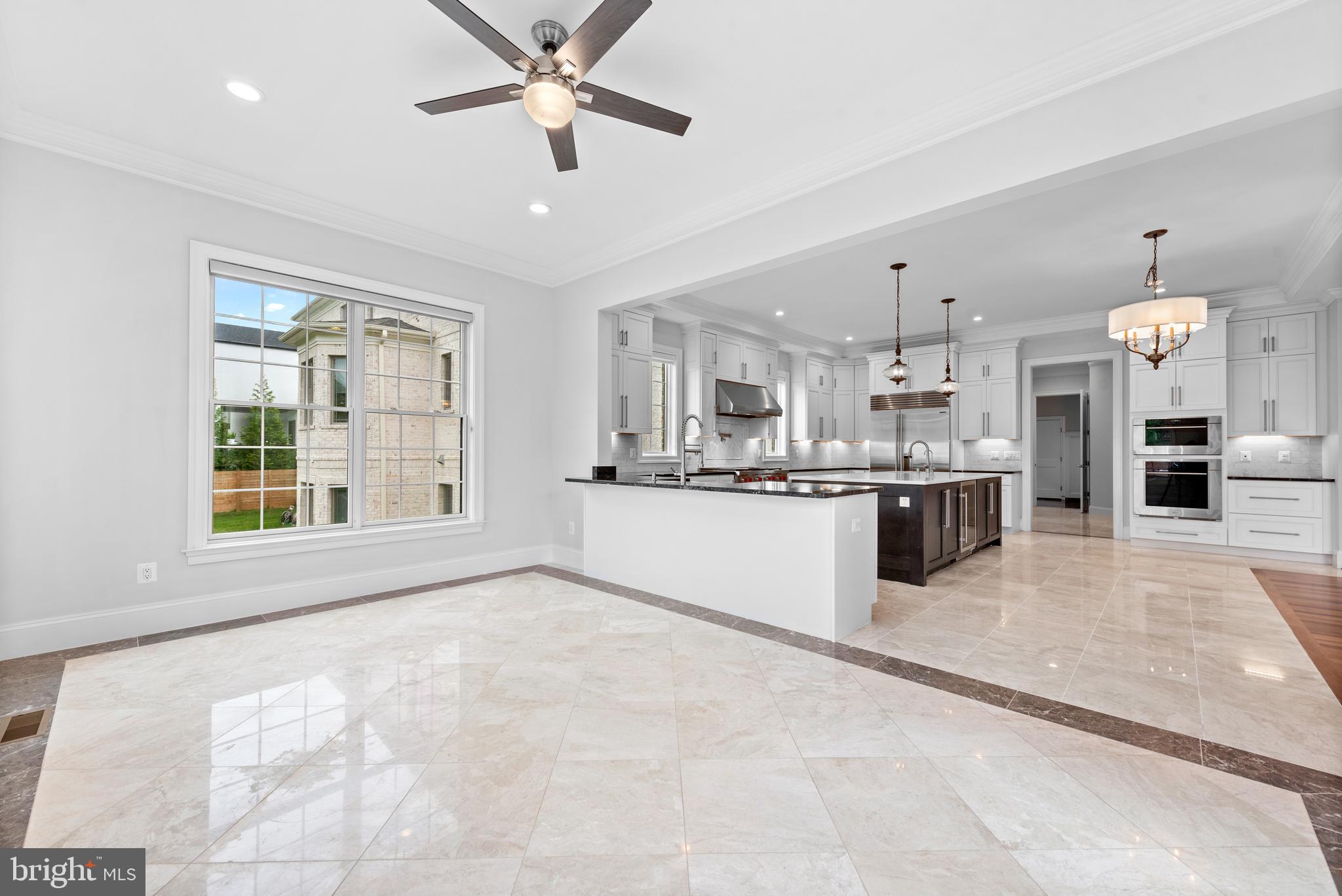 7003 Churchill Road McLean, VA 22101 - Photo 27 of 76 a large white kitchen with kitchen island a large counter top space a sink stainless steel appliances and cabinets