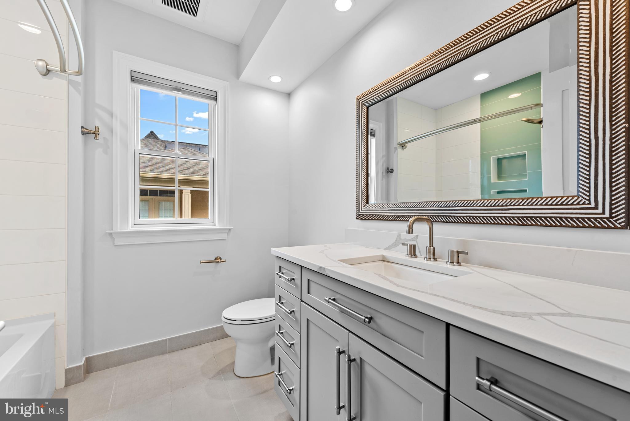 7003 Churchill Road McLean, VA 22101 - Photo 46 of 76 a bathroom with a granite countertop toilet a sink and a mirror