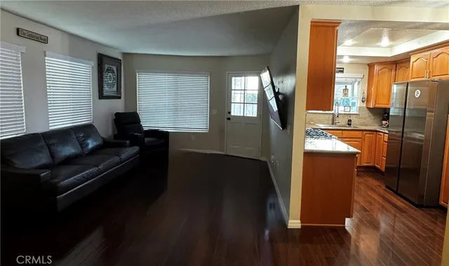 a kitchen with stainless steel appliances granite countertop a refrigerator a stove and a wooden floors