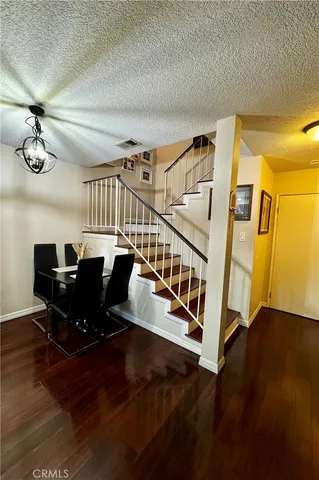 a view of a dining room with furniture a chandelier and wooden floor