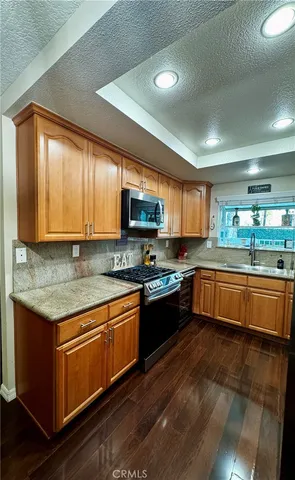a large kitchen with stainless steel appliances granite countertop a stove sink and cabinets