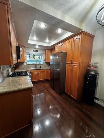 a kitchen with stainless steel appliances granite countertop a sink a stove and a refrigerator