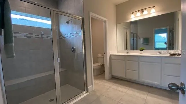 a bathroom with a double vanity sink mirror and shower