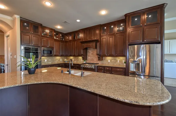 a kitchen with sink a refrigerator and chairs