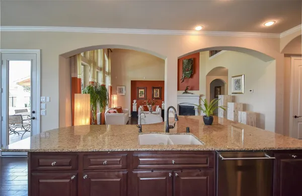 a kitchen with granite countertop a sink and cabinets with wooden floor