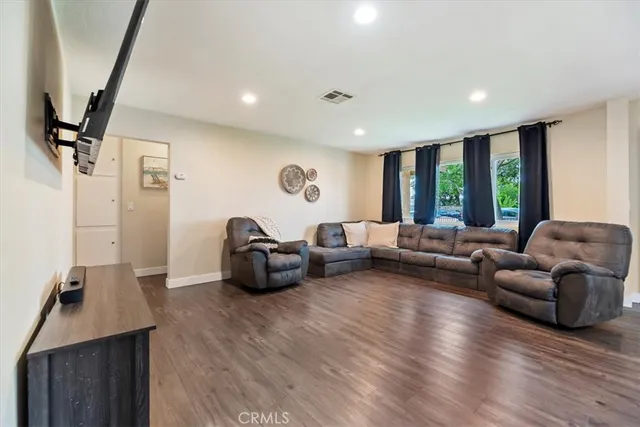 a living room with furniture floor to ceiling window and wooden floor