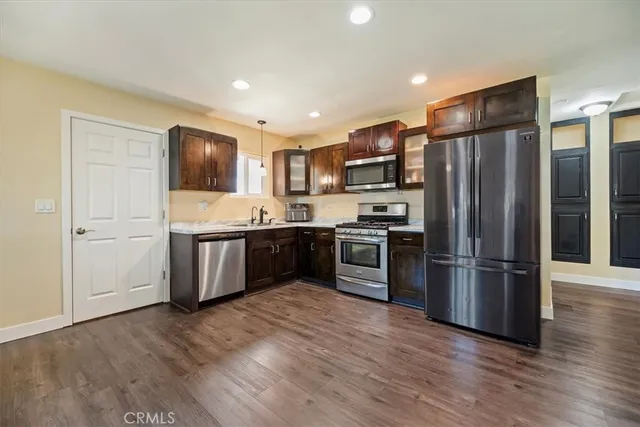 a kitchen with stainless steel appliances a refrigerator and a stove top oven