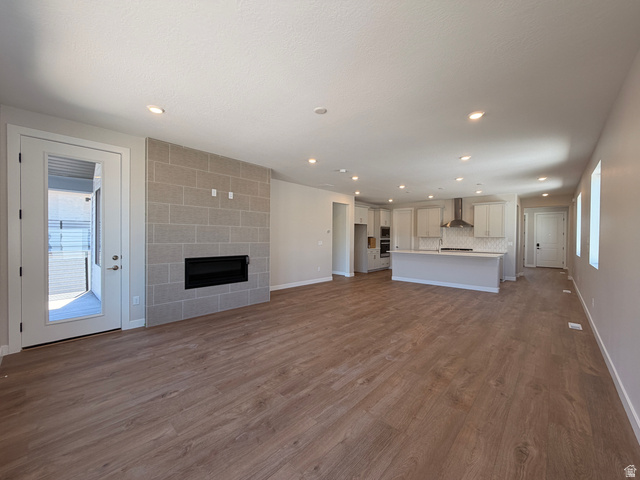 539 East Rimrock Lane Heber City, UT 84032 - Photo 7 of 13 Spacious open-concept living area featuring wood-finish flooring, recessed lighting, and a modern fireplace with a light-toned brick surround