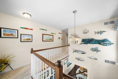 a view of hallway with furniture and wooden floor