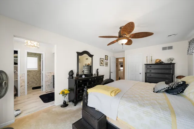 a bedroom with a large bed and ceiling fan