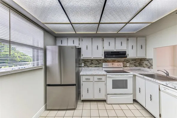 a kitchen with stainless steel appliances a refrigerator sink and cabinets
