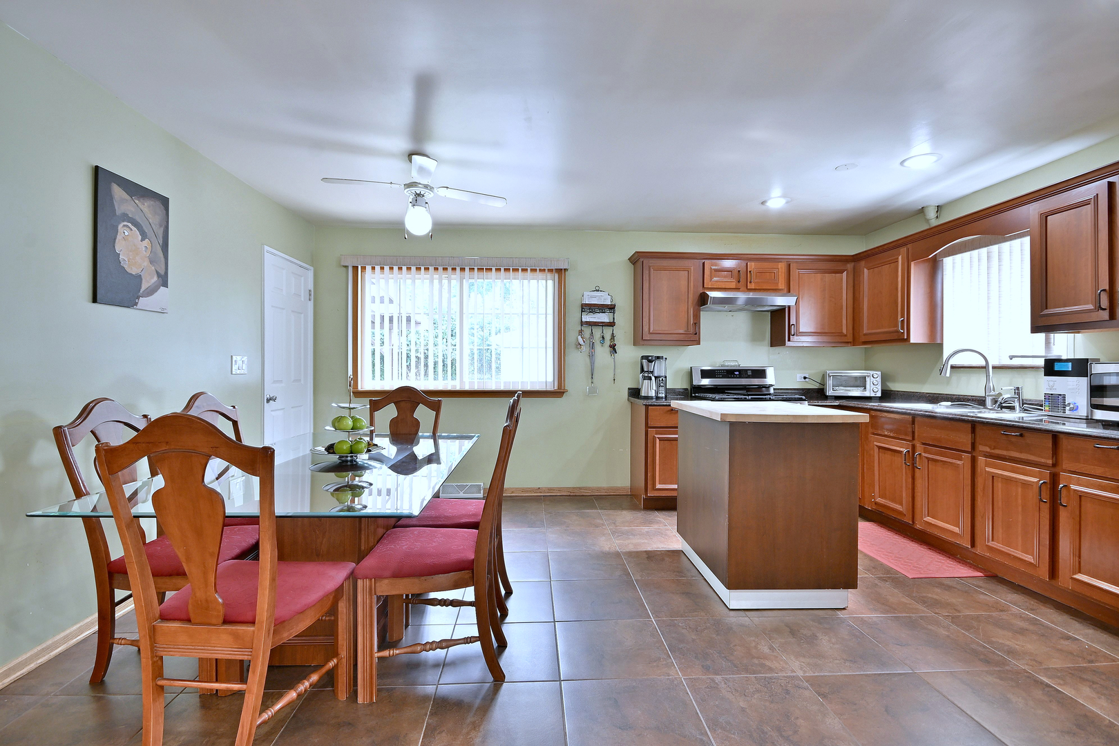 511 West Byron Avenue Addison, IL 60101 - Photo 10 of 31 a kitchen with stainless steel appliances granite countertop a stove a sink a dining table and chairs