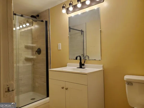 a bathroom with a sink shower and a mirror