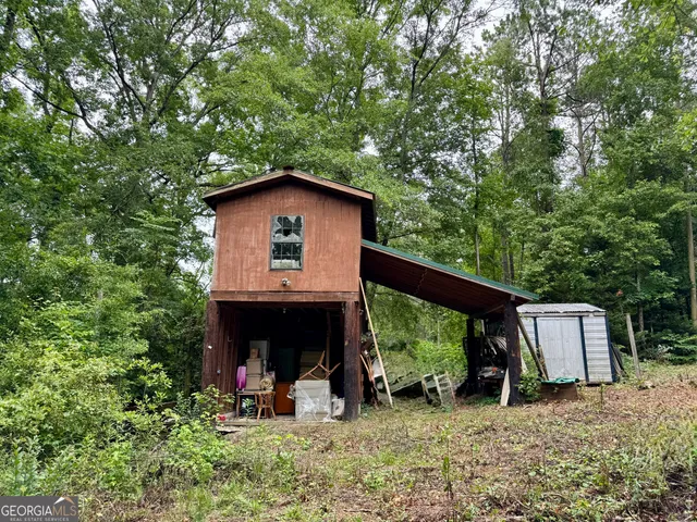 a view of backyard with wooden fence and large trees
