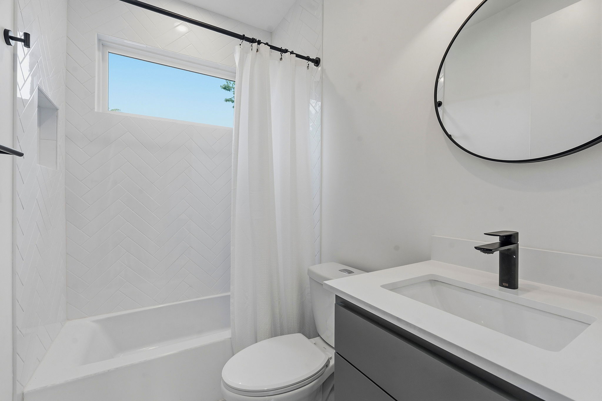 1707 Deloney Street, Unit 2 Austin, TX 78721 - Photo 21 of 26 A sleek vanity with integrated sink and modern faucet offers refined functionality in this well-appointed bathroom.