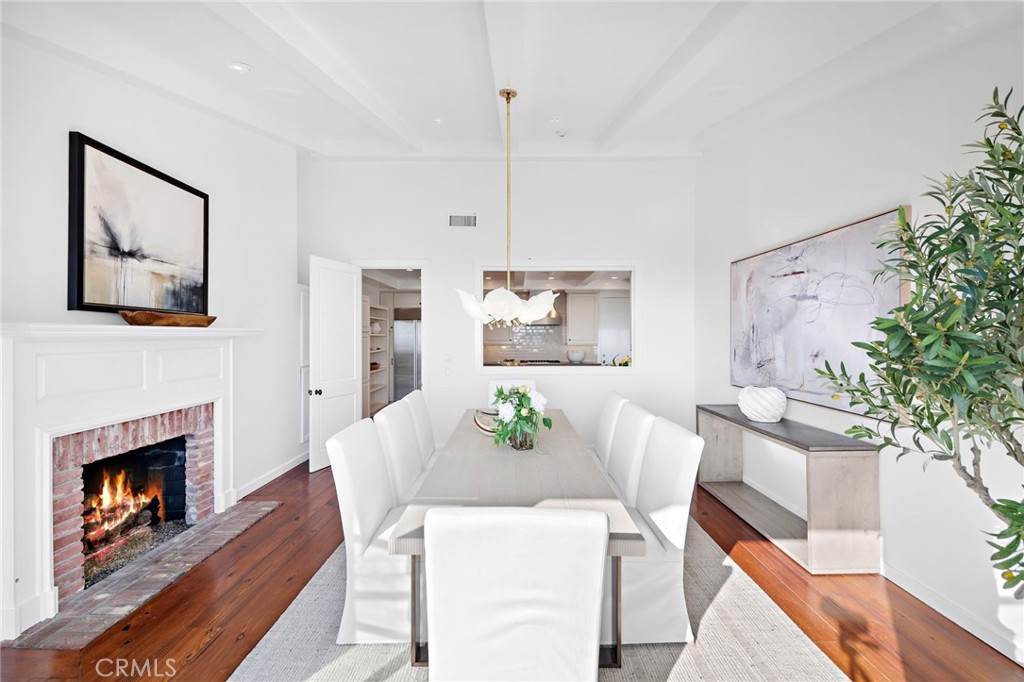 521 Kings Road Newport Beach, CA 92663 - Photo 22 of 48 a view of a dining room with furniture wooden floor and a fireplace