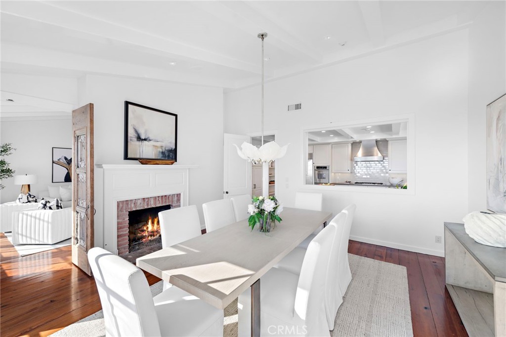 521 Kings Road Newport Beach, CA 92663 - Photo 23 of 48 a view of a dining room with furniture a fireplace and wooden floor