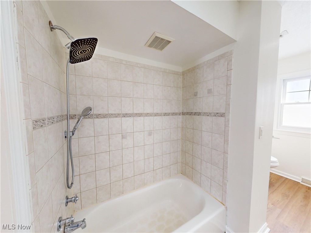 1343 Irene Road Lyndhurst, OH 44124 - Photo 12 of 32 Bathroom featuring tiled shower / bath, wood-type flooring, and toilet