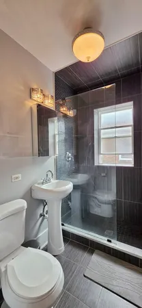 a bathroom with a sink a toilet and shower